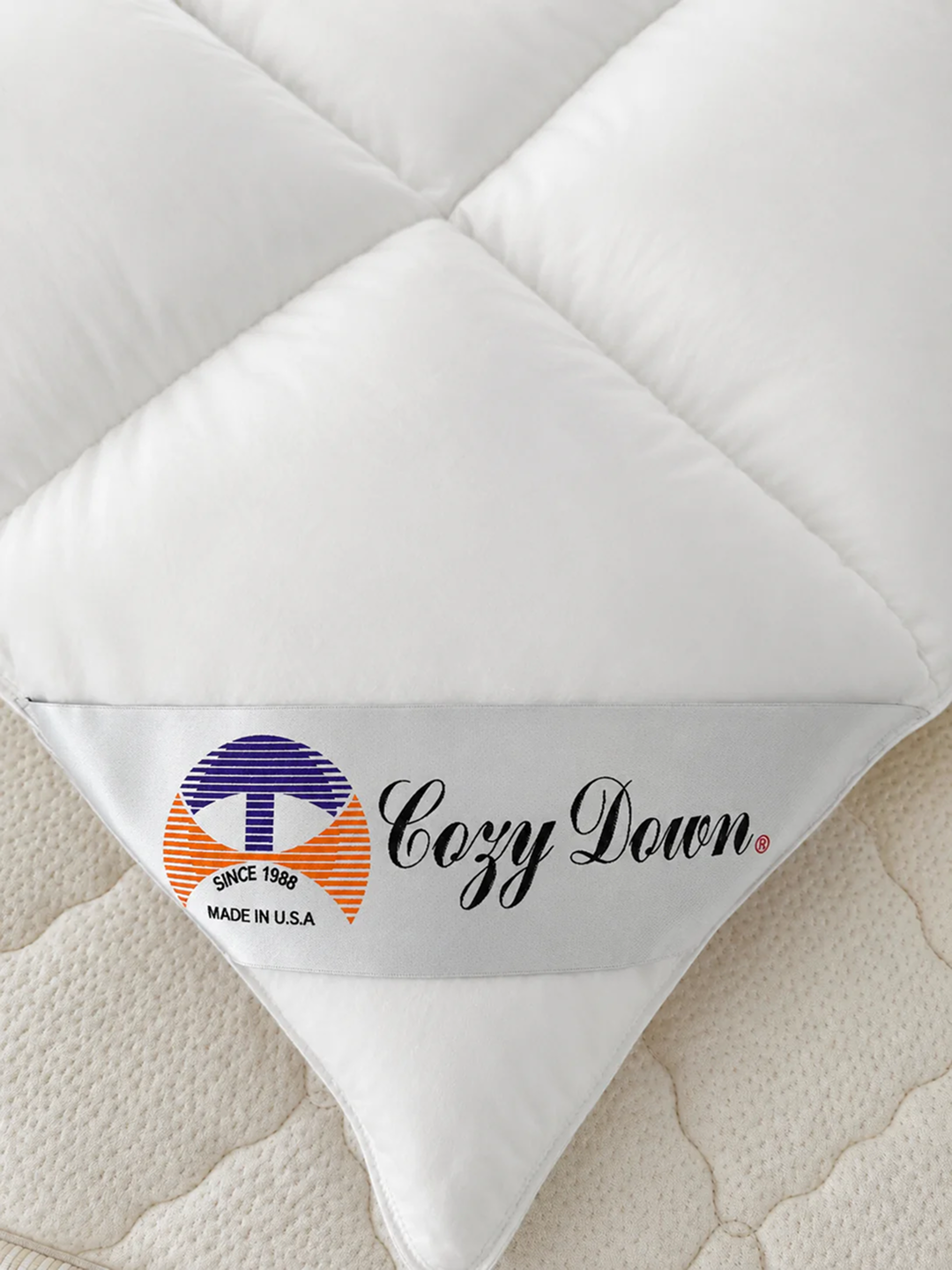 Cozy Down brand label on a white Siberian White Goose Down Comforter by Royal-Pedic Mattress