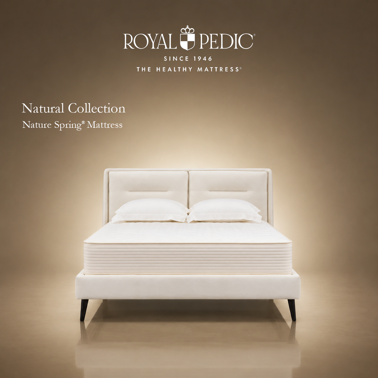 Royal Pedic Nature Spring Mattress from the Natural Collection on a white upholstered bed frame with two pillows against a tan background