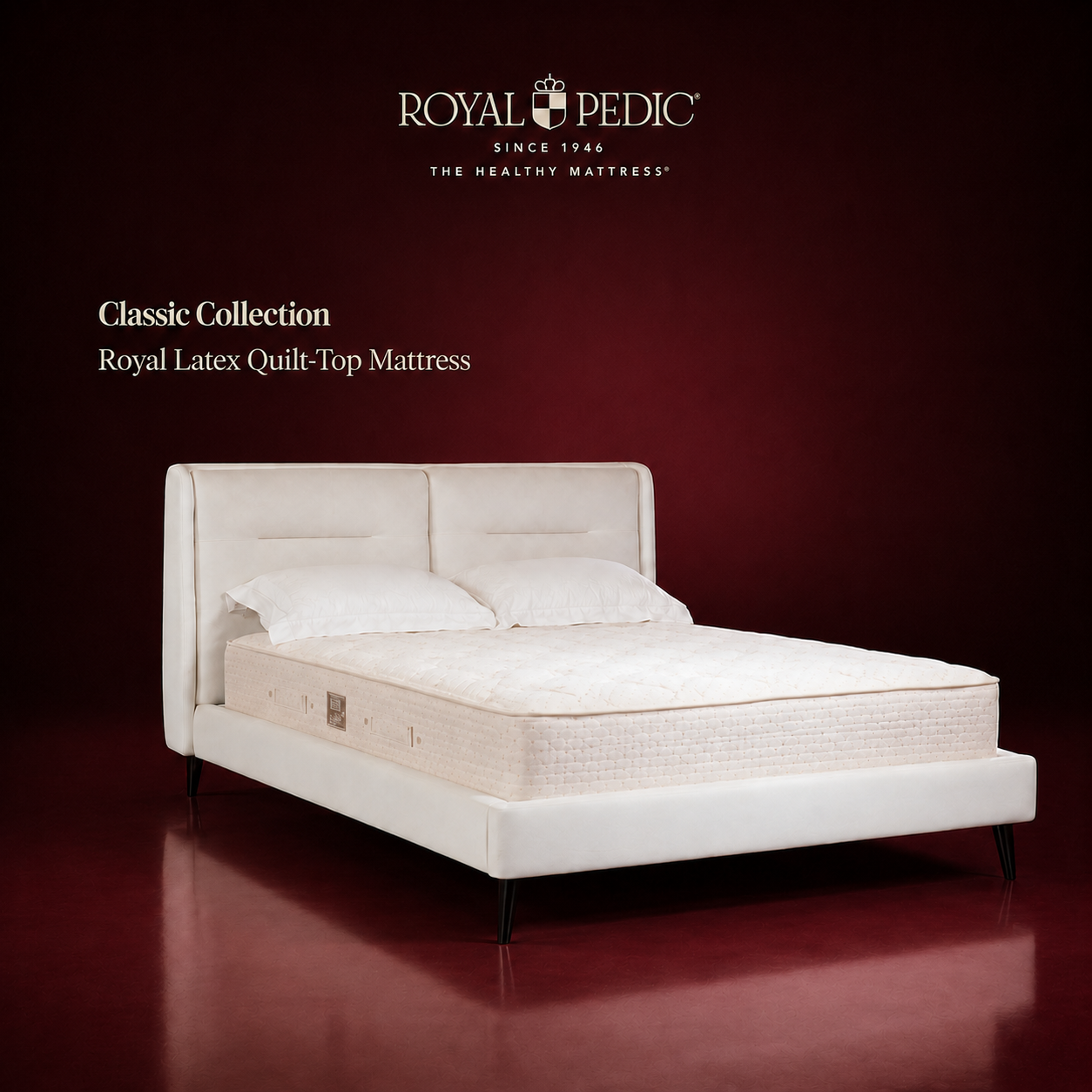 Royal Pedic Royal Latex Quilt-Top Mattress on a white upholstered bed frame against a dark red background with brand logo and text