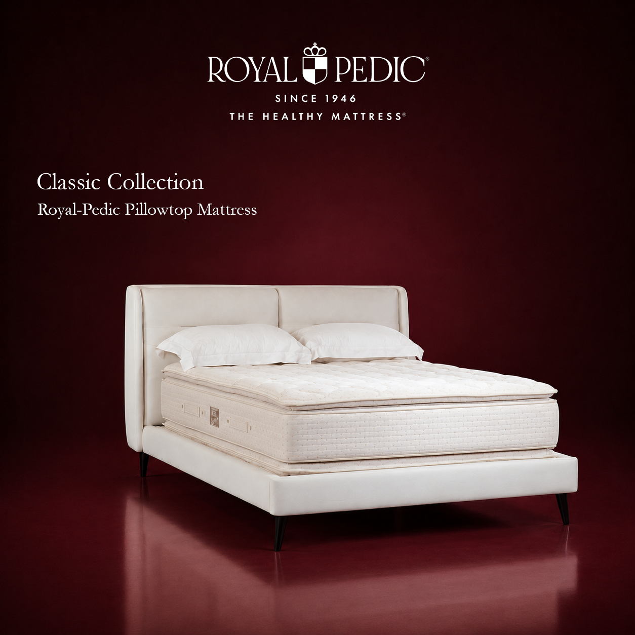 Royal-Pedic Pillowtop Mattress from the Classic Collection on a white upholstered bed frame against a dark red background