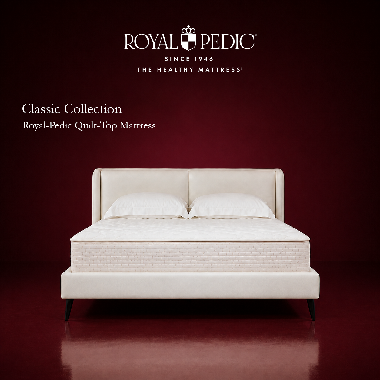 Royal-Pedic Quilt Top Mattress on a cream upholstered bed frame against a dark red background with Royal-Pedic logo