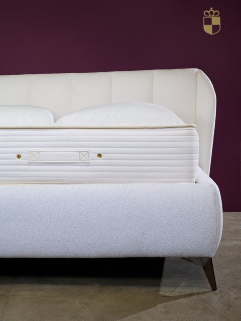 Royal-Pedic Mattress Dream Spring Limited Mattress on a white bed frame with a purple wall background.