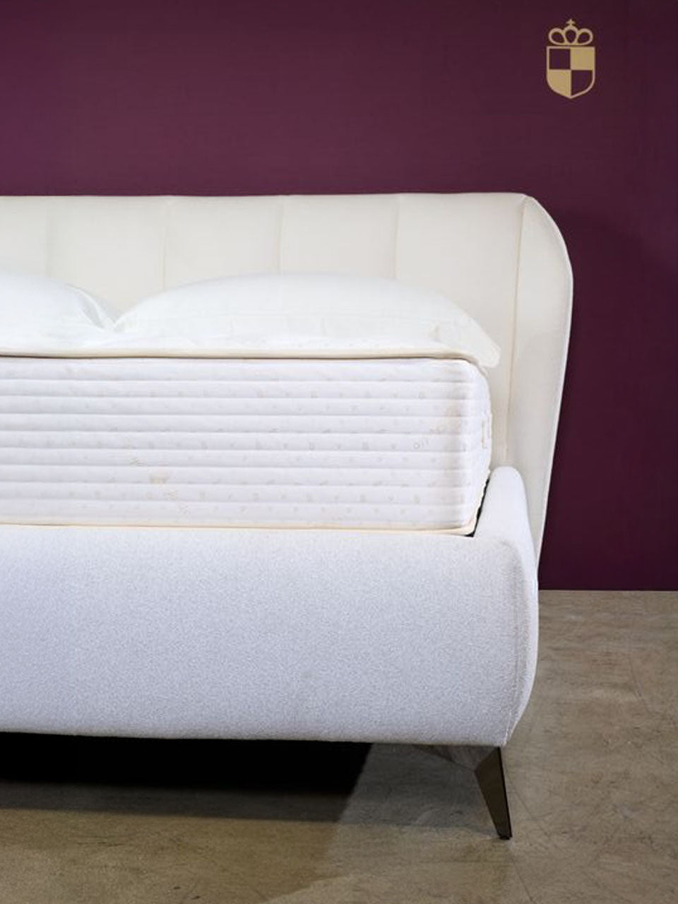 Royal-Pedic Dream Spring Mattress on a white upholstered bed frame against a deep purple wall with a gold Royal-Pedic logo.