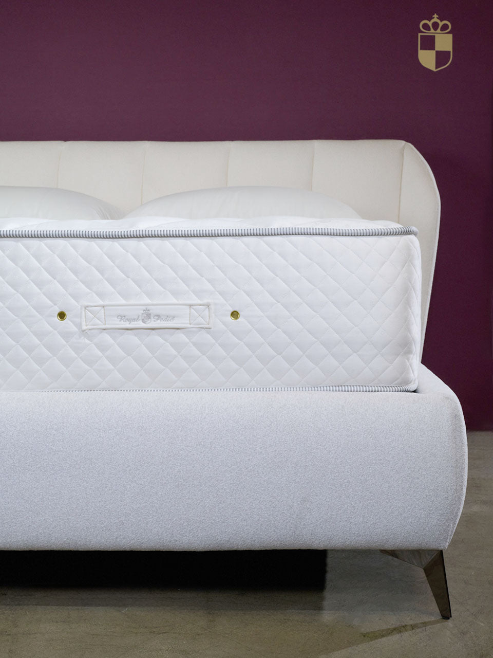 Royal-Pedic Mattress Dream Spring® Ultimate Mattress with a white quilted top, on a light grey bed frame.