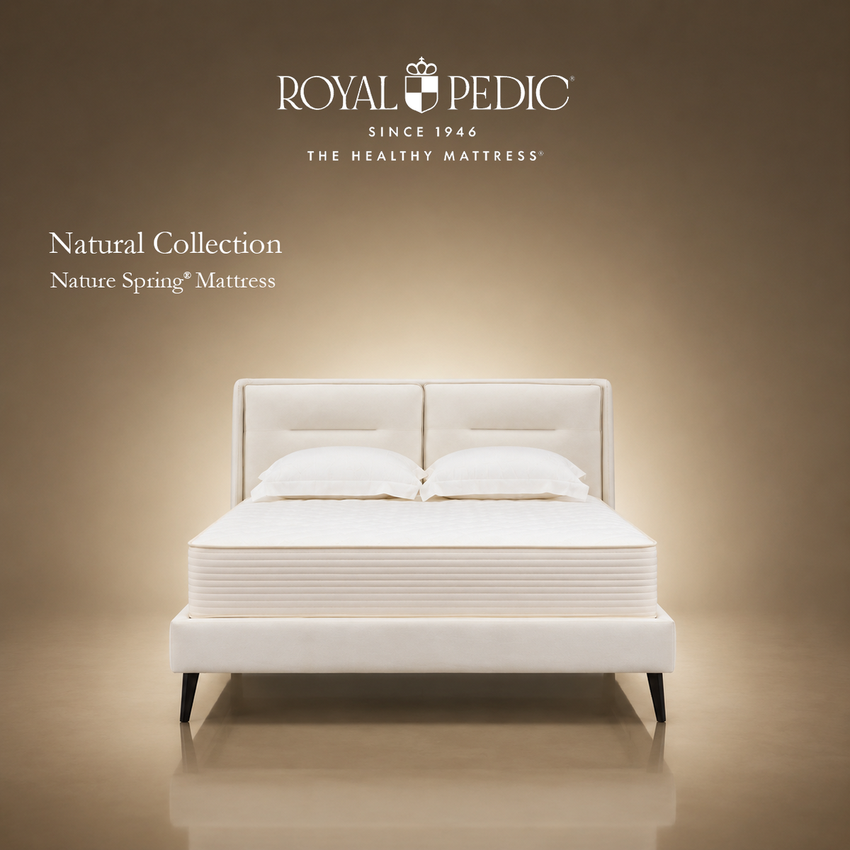 Royal Pedic Nature Spring Mattress from the Natural Collection on a white upholstered bed frame with two pillows against a tan background