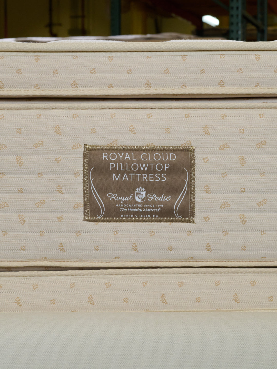 Close-up of the Royal Cloud Pillowtop Mattress by Royal-Pedic, showing the brand label and quilted pattern.