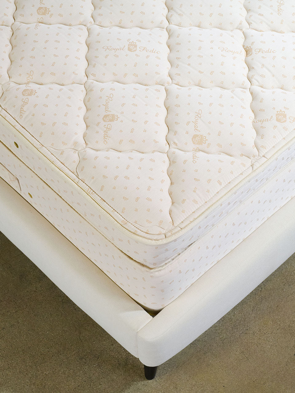 Close-up of a white mattress and pillowtop pad with Royal-Pedic branding on the quilting