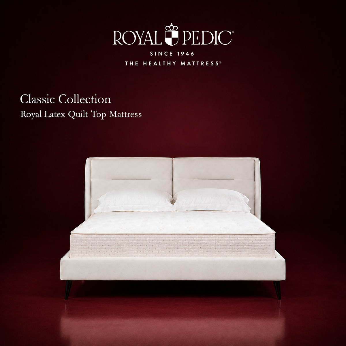 Royal Pedic Royal Latex Quilt-Top Mattress on a white upholstered bed frame against a dark red background