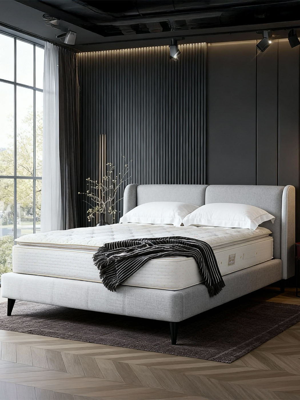 Royal-Pedic Pillowtop Mattress on a grey bed frame in a modern bedroom with dark walls and a large window.